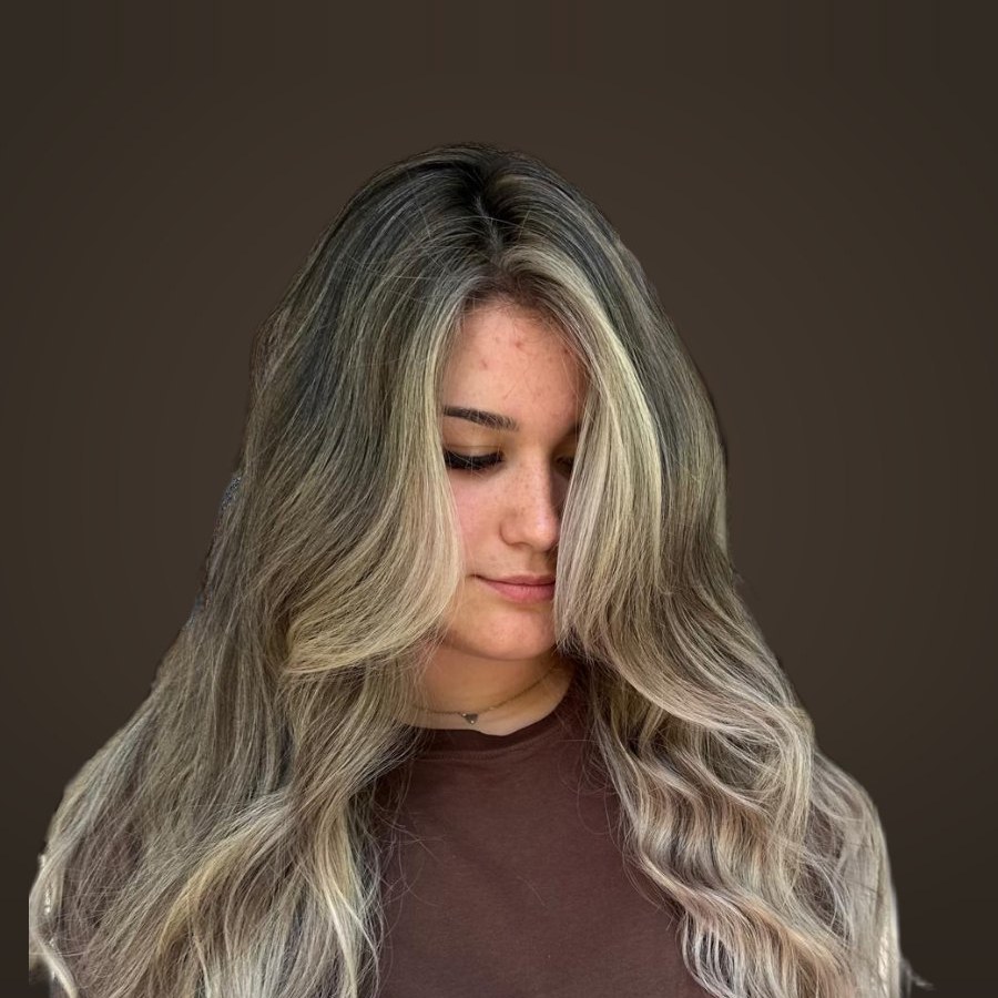 Balayage blond nisipiu pe păr lung ondulat