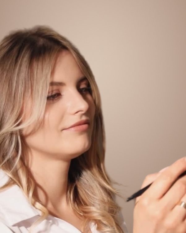 Doina Baran, make-up artist și hair stylist, lucrând cu pensula de machiaj
