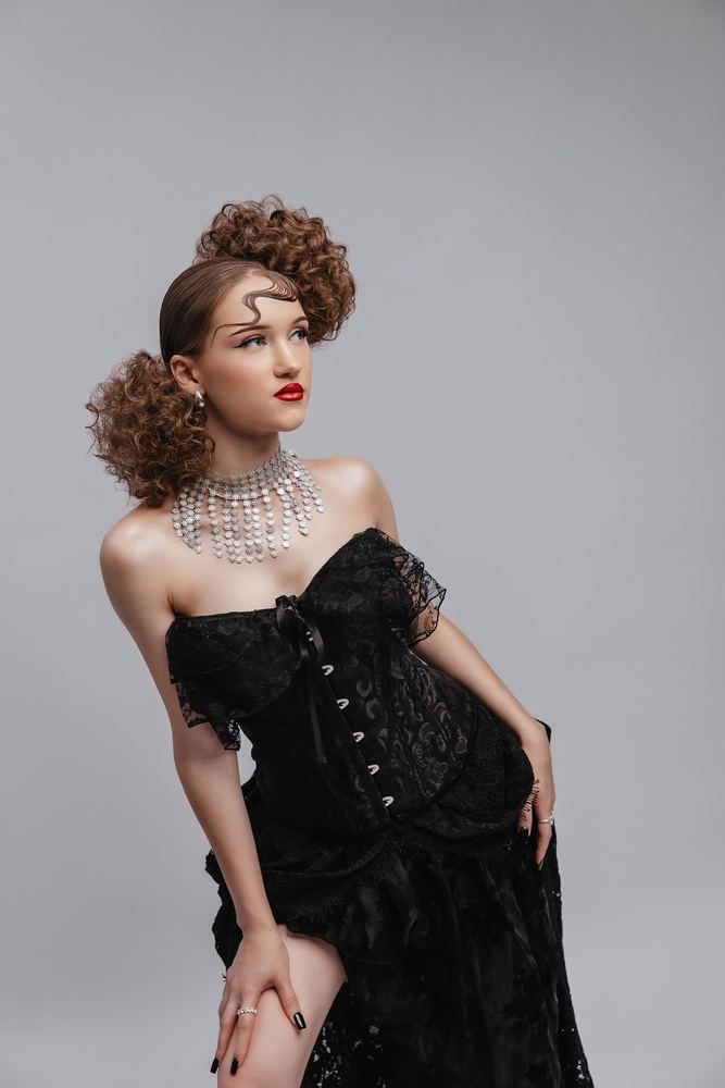 Look complet de concurs: coafură cu bucle caramel, corset negru și machiaj de scenă